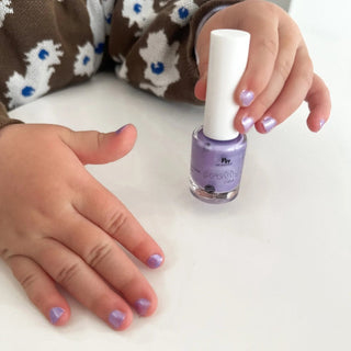 Child painting nails with the best nail polish for toddlers, a scented peel off nail polish free from harmful ingredients