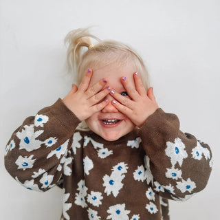 Child painting nails with the best nail polish for toddlers, a scented peel off nail polish free from harmful ingredients