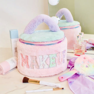 Pastel-colored kids makeup bag with 'MAKEUP' text, surrounded by makeup items on a light surface.