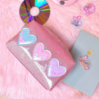 Pink glitter kids makeup bag with three pastel sequin hearts on the front