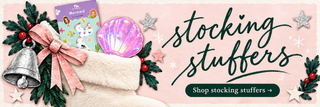 Stocking stuffers — fluffy cream stocking, mermaid nail stickers and an iridescent clamshell mirror on pale pink. Shop stocking stuffers.