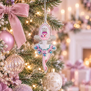 Sugarplum Fairy Ornament hanging on a Christmas tree with pink velvet ribbon, pastel baubles and warm white lights.